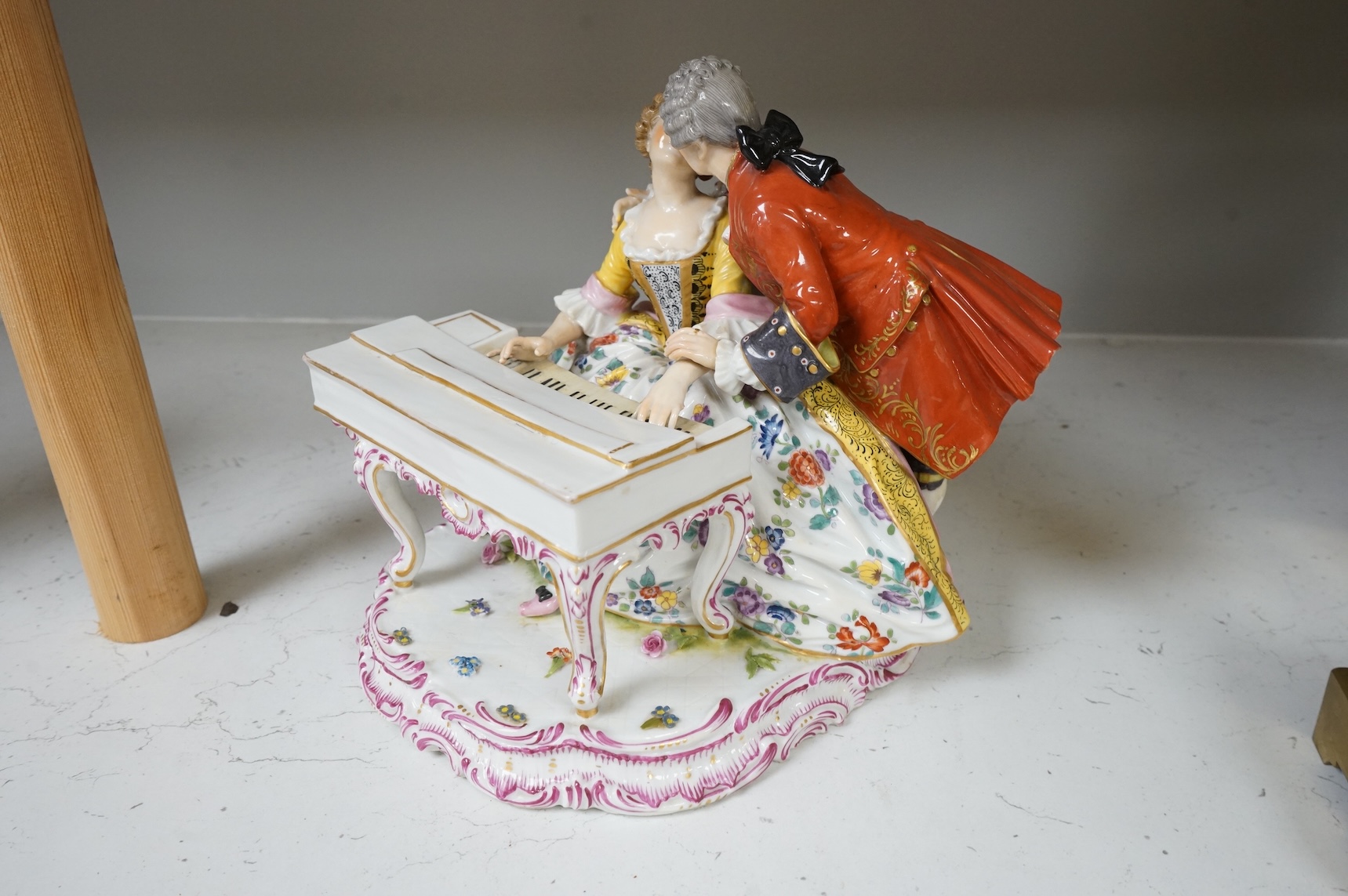 A large German porcelain group lovers at a piano, 22cm high